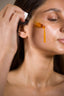 A woman applying natural oil on her face