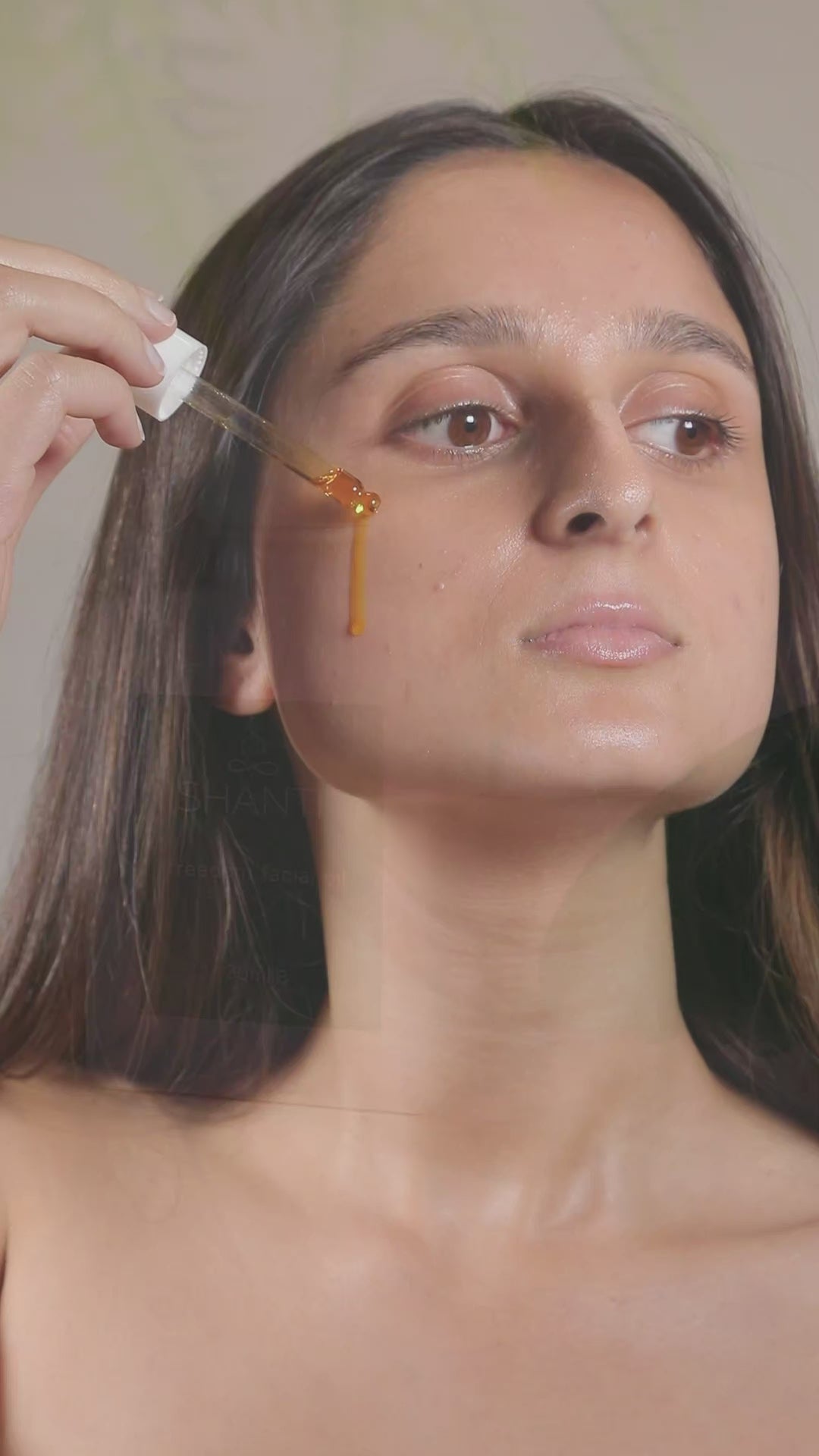 Video of a woman applying freedom facial oil and using gua sha tool on her face.